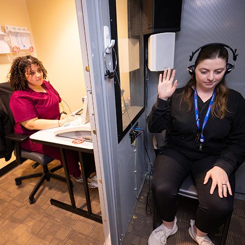 Iyanna Nieves working in the speech clinic with another student.