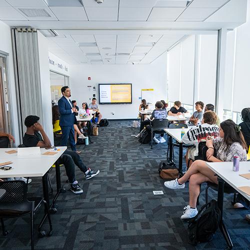 An interactive classroom setting featuring a presentation by Dr. Aakash Sapru.