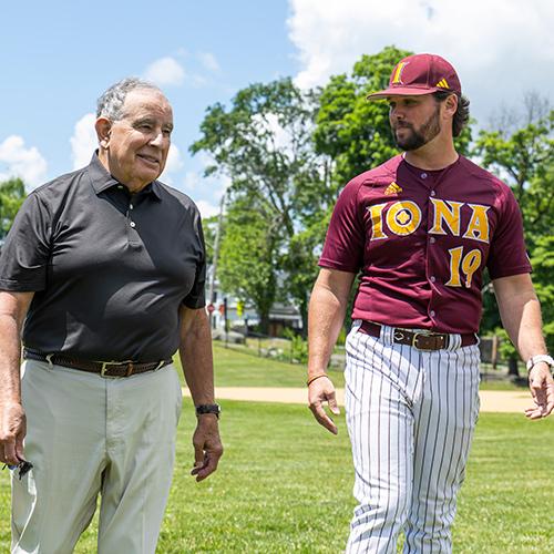 Coach Al Zoccolillo walks with an Iona baseball player.