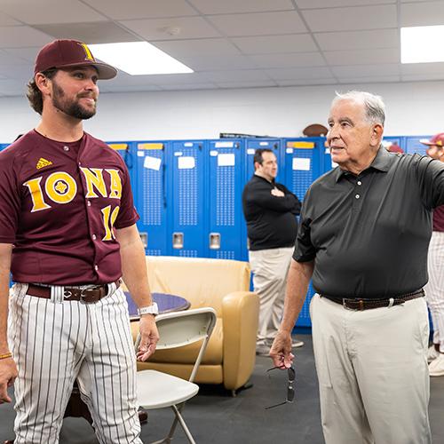 Coach Al Zoccolillo talks with an athlete in the locker room.