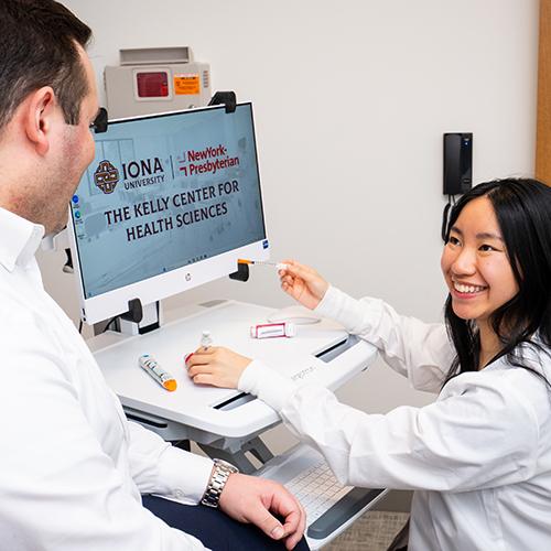 Two FNP students at a computer reviewing medication protocols.
