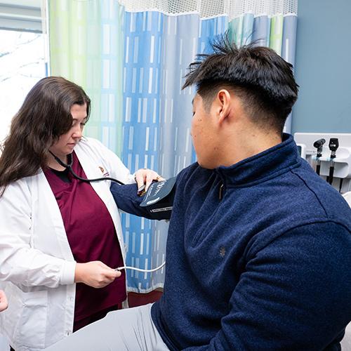An FNP student practices measuring blood pressure.