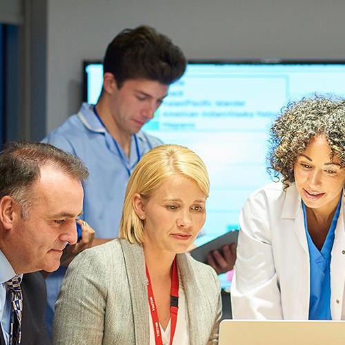Healthcare workers and admins work together on a project.