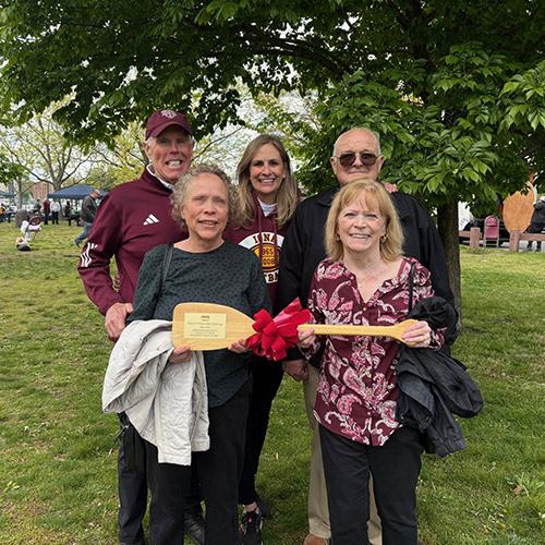 The Trainors hold a celebratory mini oar.