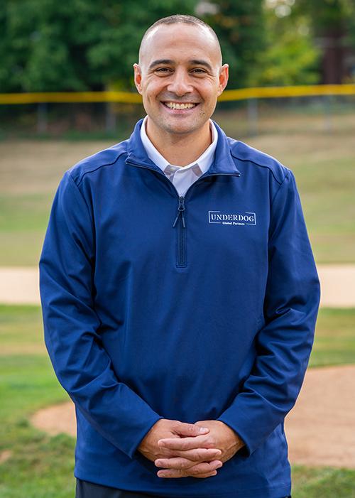 Matt Rizzetta on the baseball field in a blue Underdog jacket.