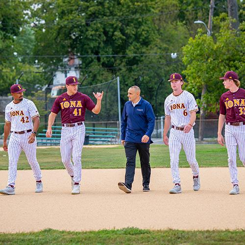 Matt Rizzetta Speaking With Four Baseball Players On The Baseball Field
