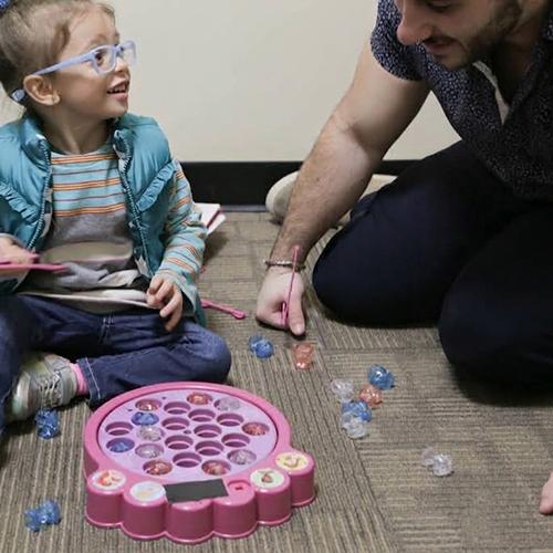 A speech pathologist uses games to help a young client learn.