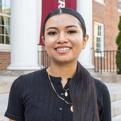 Kimberly Romero ’27 smiles outside a campus building at Iona University.
