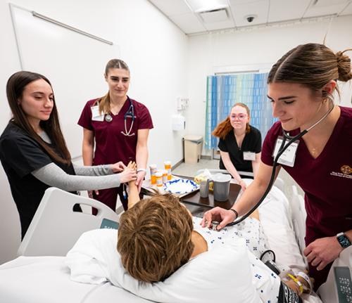 Nursing students practice in the health sciences simulation lab.