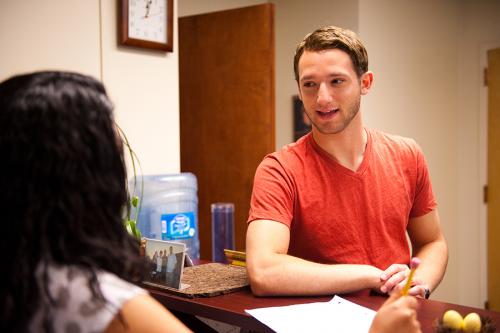A student leans over to talk with a staff member from the Office of Career Development.